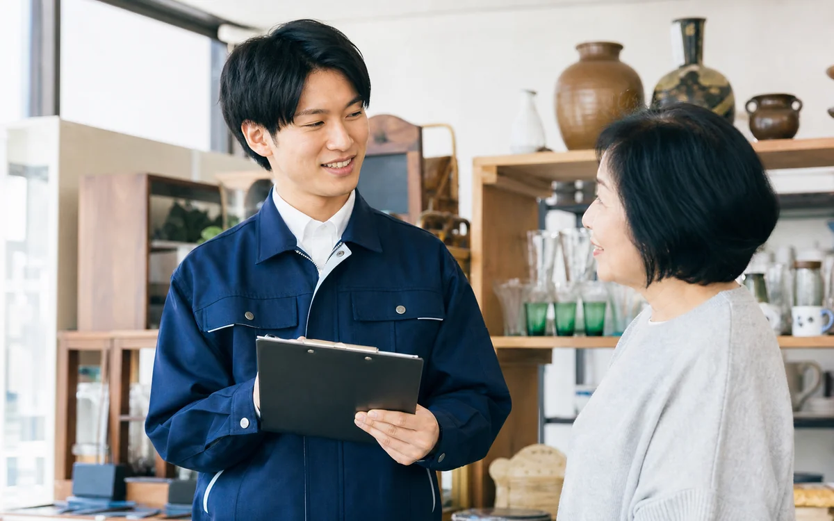 店内でお客様に買取内容を説明する高く買取るゾウのスタッフ